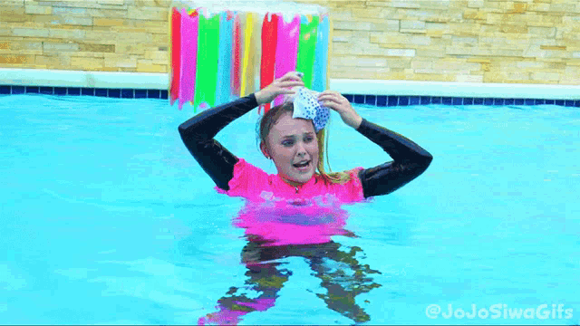 a girl in a pink shirt is in a swimming pool with jojo siwa gifs written on the bottom