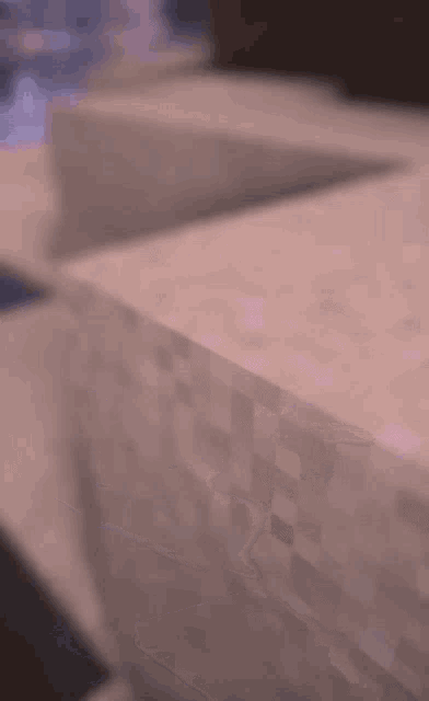 a blurred image of a minecraft world with mountains in the background and a river in the foreground .