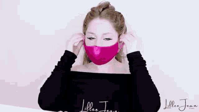 a woman wearing a pink face mask with a kiss on it .