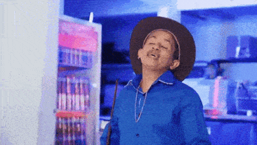 a man wearing a cowboy hat and a blue shirt