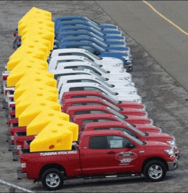 a row of red tundra trucks are parked in a parking lot