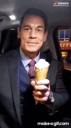 a man in a suit and tie holds an ice cream cone