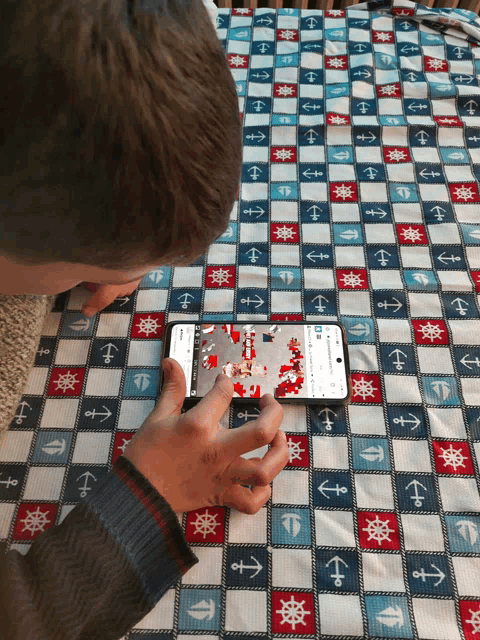 a person is playing a game on a phone on a checkered table cloth