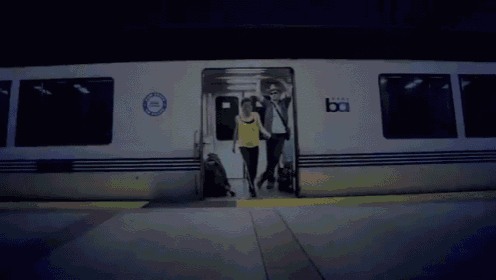 a couple walking out of a train that says boi on it