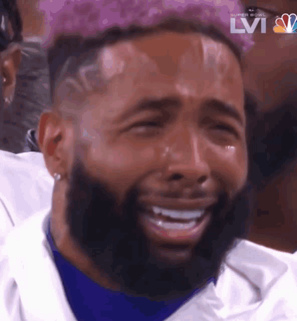 a man with a beard is crying while watching a super bowl on nbc