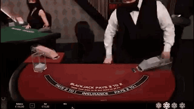 a man in a tuxedo is playing blackjack in a casino .