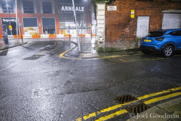 a car is parked on the side of the road in front of arndale