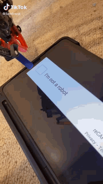 a tiktok video shows a toy robot holding a pencil and a screen that says i 'm not a robot