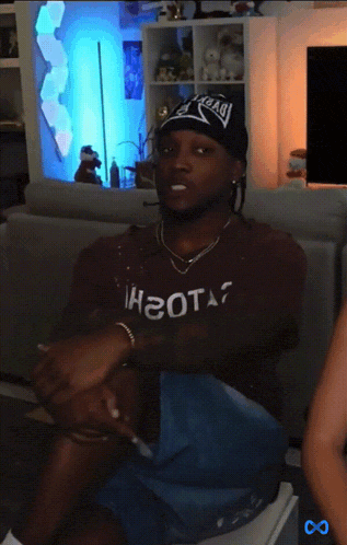 a man sitting on a couch wearing a shirt that says ihgota