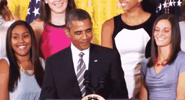 a man in a suit and tie stands in front of a podium with the seal of the president of the united states