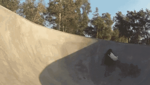 a skateboarder is doing a trick on a ramp at a skate park