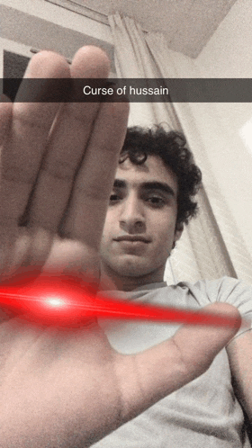 a man is holding up his hand with a caption curse of hussain