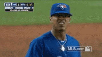 a baseball player wearing a blue jersey is standing on a field