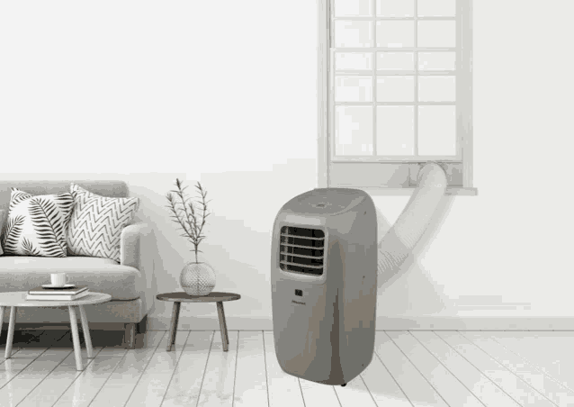 a portable air conditioner in a living room with a couch and table