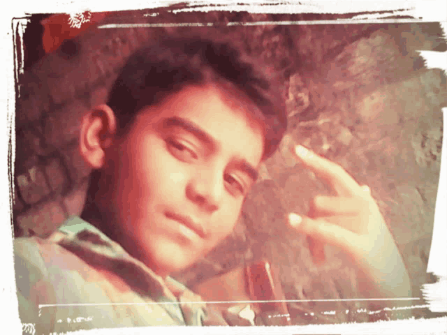 a young boy giving the middle finger in a photo