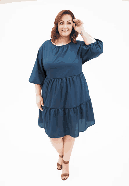 a plus size model wearing a blue dress