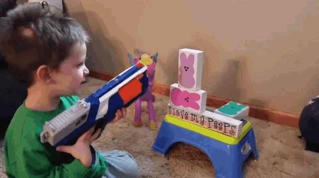 a boy playing with a nerf gun in front of a sign that says " i love my peeps "