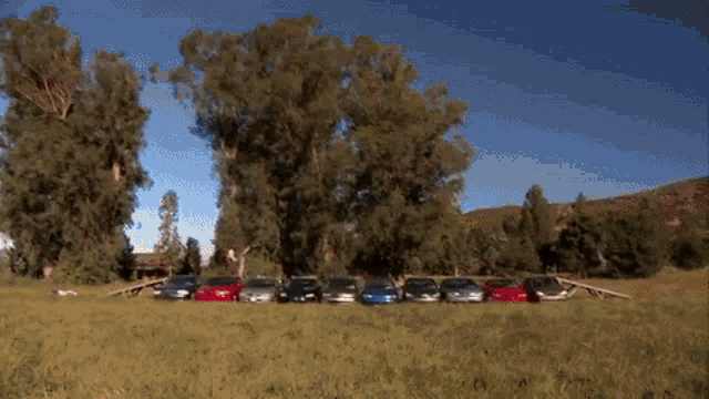 a man in a red suit is jumping over a wooden fence .