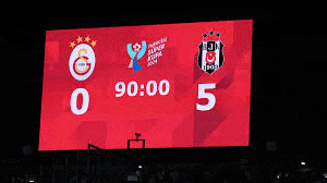 a large screen shows the score of a soccer match between galatasaray and beşiktaş .