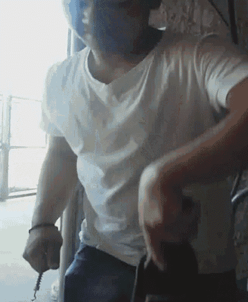 a man in a white shirt is holding a screwdriver in his right hand