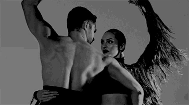 a black and white photo of a man and woman dancing .
