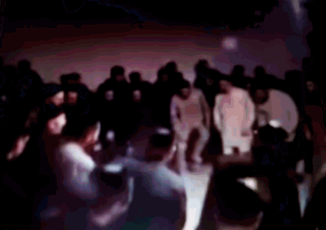 a blurry image of a crowd of people standing in a dark room