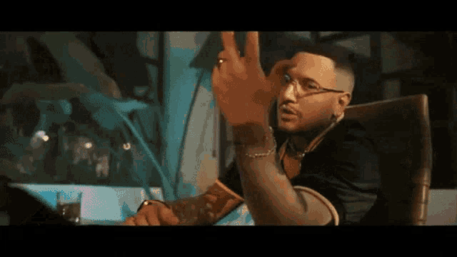 a man is sitting in a chair giving the middle finger .