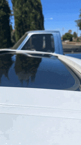 a white truck with a sunroof is parked on a sunny day