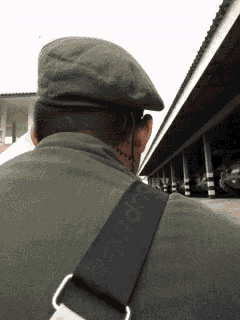 a man wearing a green hat and a black strap that says adidas