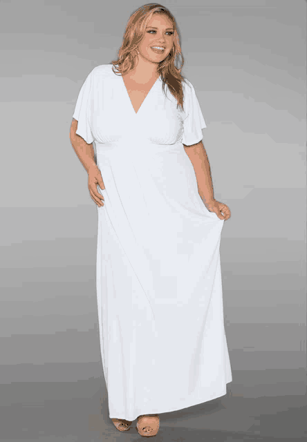 a plus size model wearing a white dress with a plunging neckline