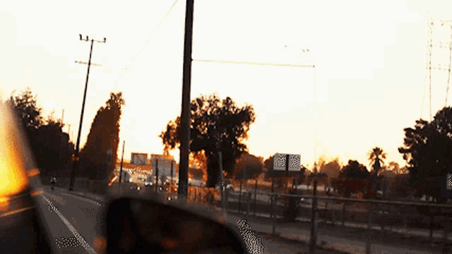 a sunset is reflected in the rear view mirror of a vehicle