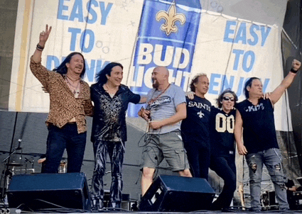 a group of men are standing on a stage in front of a bud light sign