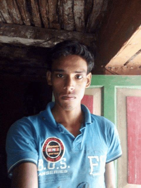 a young man wearing a blue b.o.s. anseries polo shirt