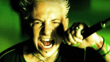 a man with blonde hair is singing into a microphone .