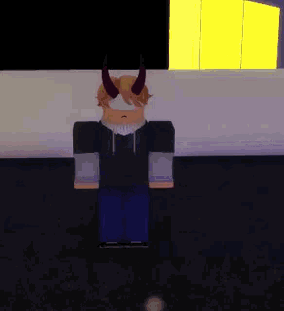 a roblox character with horns and a hoodie is standing in front of a wall .