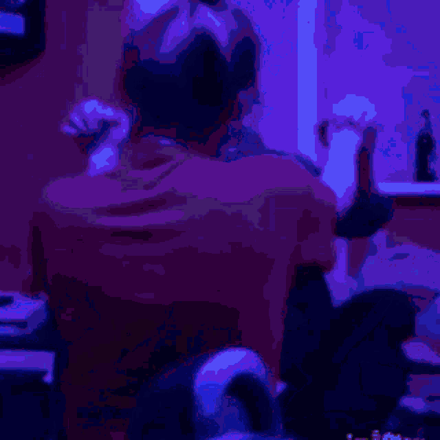 a man and a woman are sitting next to each other in a room with a blue light behind them .