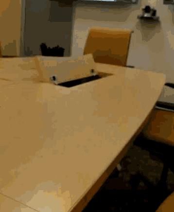 a conference room with a table and chairs and a whiteboard on the wall