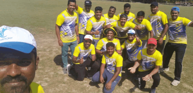 a man wearing a hat that says harmony poses for a photo with his teammates