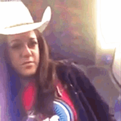 a woman wearing a white cowboy hat is sitting on an airplane .