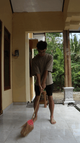 a man is sweeping the floor in front of a yellow building
