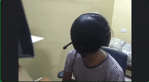 a woman wearing headphones and a headset is sitting in front of a computer screen .