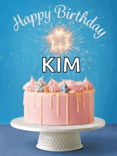 a pink birthday cake with sparklers coming out of it and the name kim on it