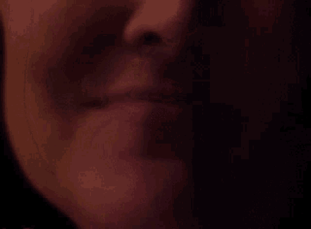a close up of a woman 's lips in the dark .