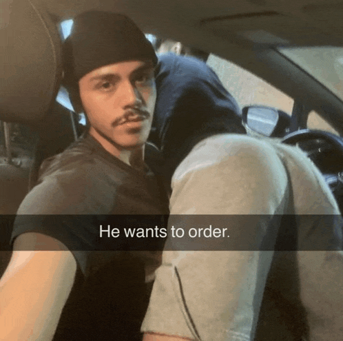 a man sitting in a car with the words he wants to order