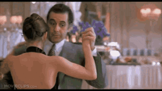 a man and a woman are dancing in a room .