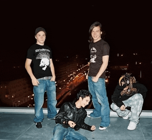 a group of young men are posing for a picture with one wearing a shirt that says social distortion