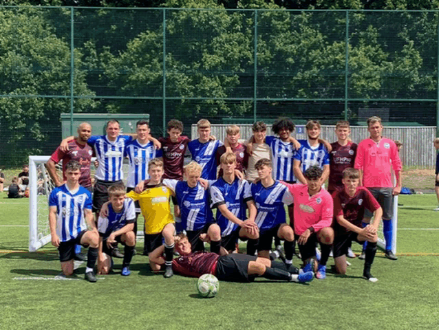 a group of soccer players posing for a photo with one wearing a pink shirt that says ' athletic club ' on it