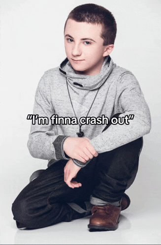 a young man is kneeling down with the words " i 'm finna crash out " written above him