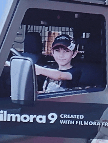 a young boy is sitting in the driver 's seat of an imora 9