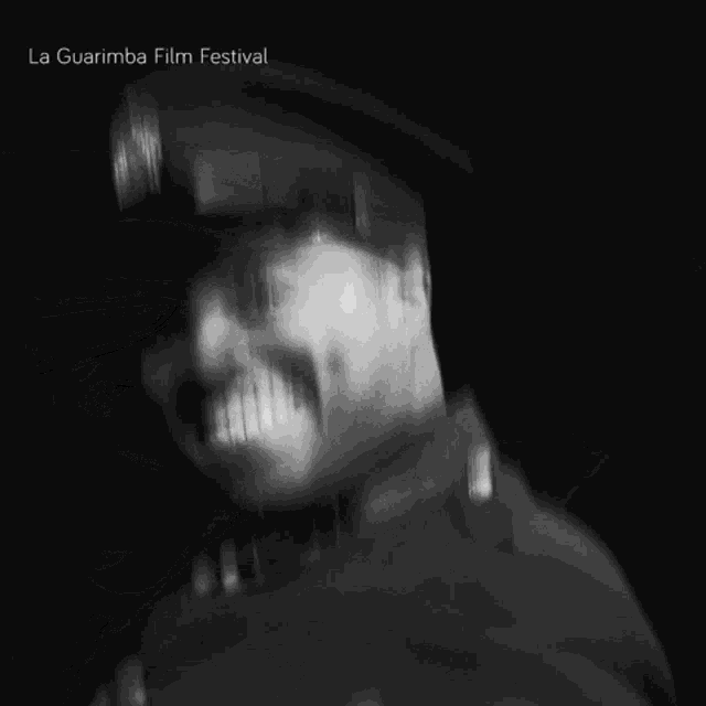 a man in a military uniform is smiling in a black and white photo with la guarimba film festival written on the bottom